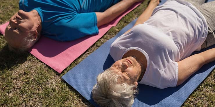 cuplu de bătrâni care practică yoga nidra