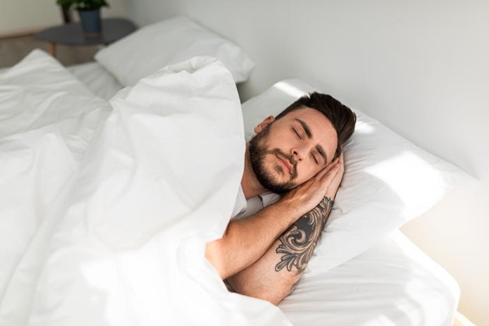 giovane uomo nel sonno profondo dopo la meditazione guidata per il sonno